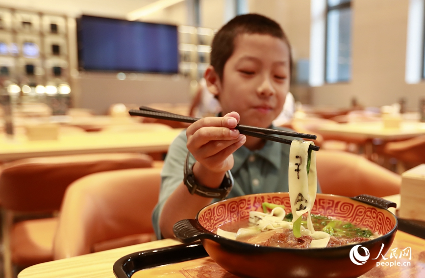 殷墟博物館推出的甲骨文面深受游客喜愛。人民網(wǎng)記者 慎志遠 攝